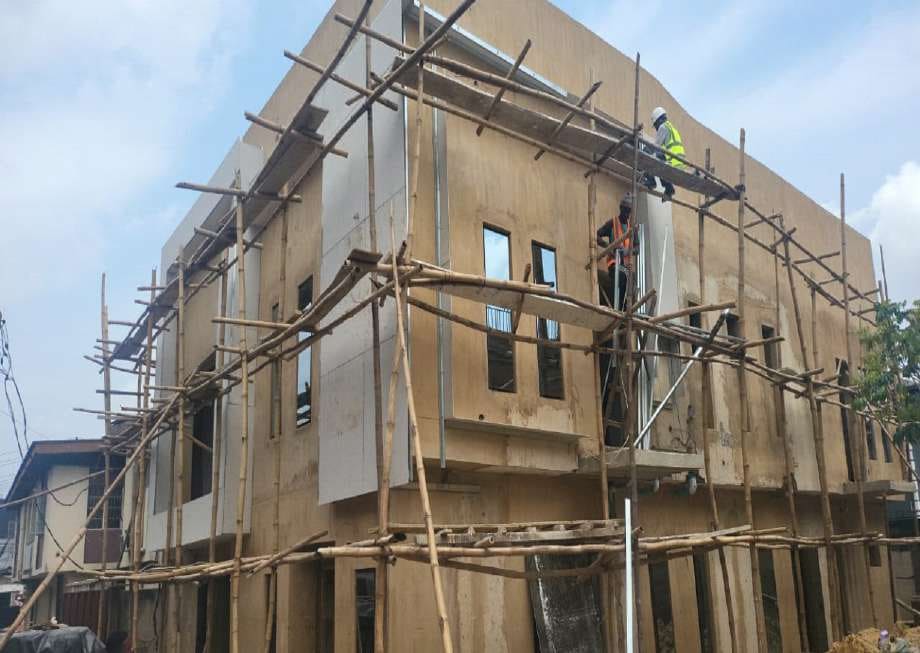 Plastering works on the scaffolded facade — Gbagada, Lagos