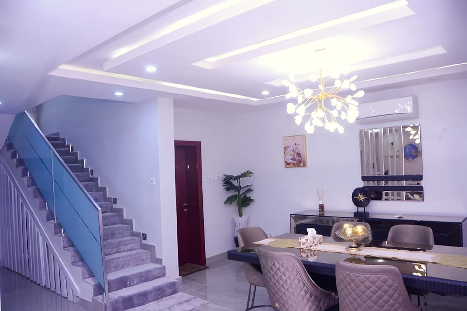 Dining room beside the glass-balustrade staircase — Gbagada, Lagos