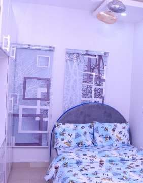 Bedroom with blue patterned bedding and wall shelving — Gbagada, Lagos