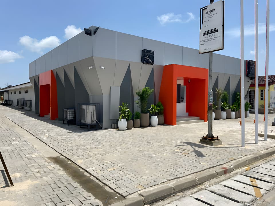 Completed branch facade, entrance and interlocking forecourt in daylight — HFP Shopping Complex, Lagos