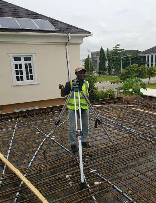 Surveyor checking levels beside slab reinforcement — Lakeview Park, Lekki, Lagos