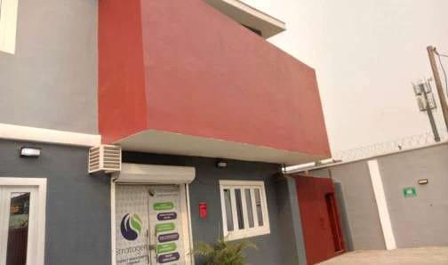 After: red projecting facade and entrance detail — Oluwaleimu Street, Ikeja, Lagos