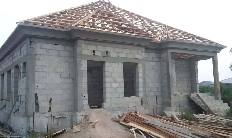Timber roof trusses above the blockwork structure — Unity Estate, Badore, Lagos