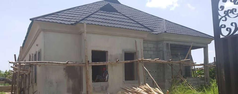 Roofed building viewed through the entrance gate — Unity Estate, Badore, Lagos